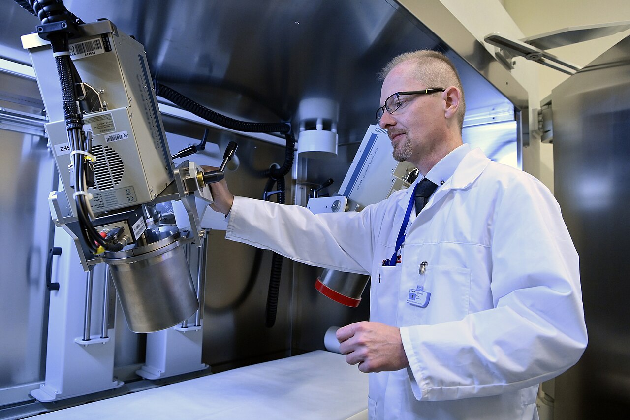 An IAEA Individual Monitoring Technician sets up the position of an electrically cooled High Purity Germanium (HPGe) detector. Below the bed, a temperature compensated Sodium Iodide (NaI(Tl)) scintillation detector is used for scanning the 