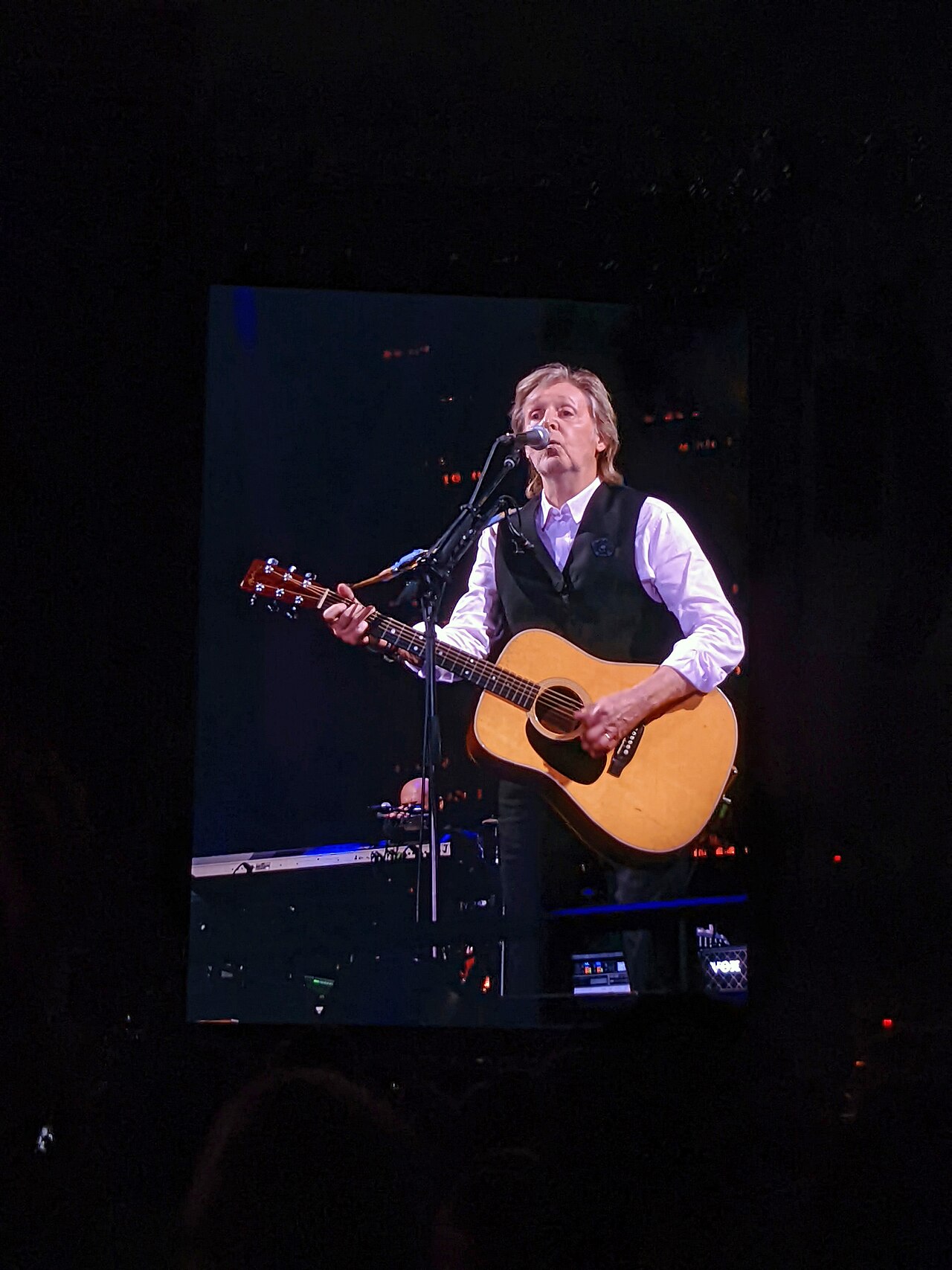 Paul McCartney performing with an acoustic guitar on the Got Back tour at Camping World Stadium in Orlando, Florida, United States, on 28 May 2022.
