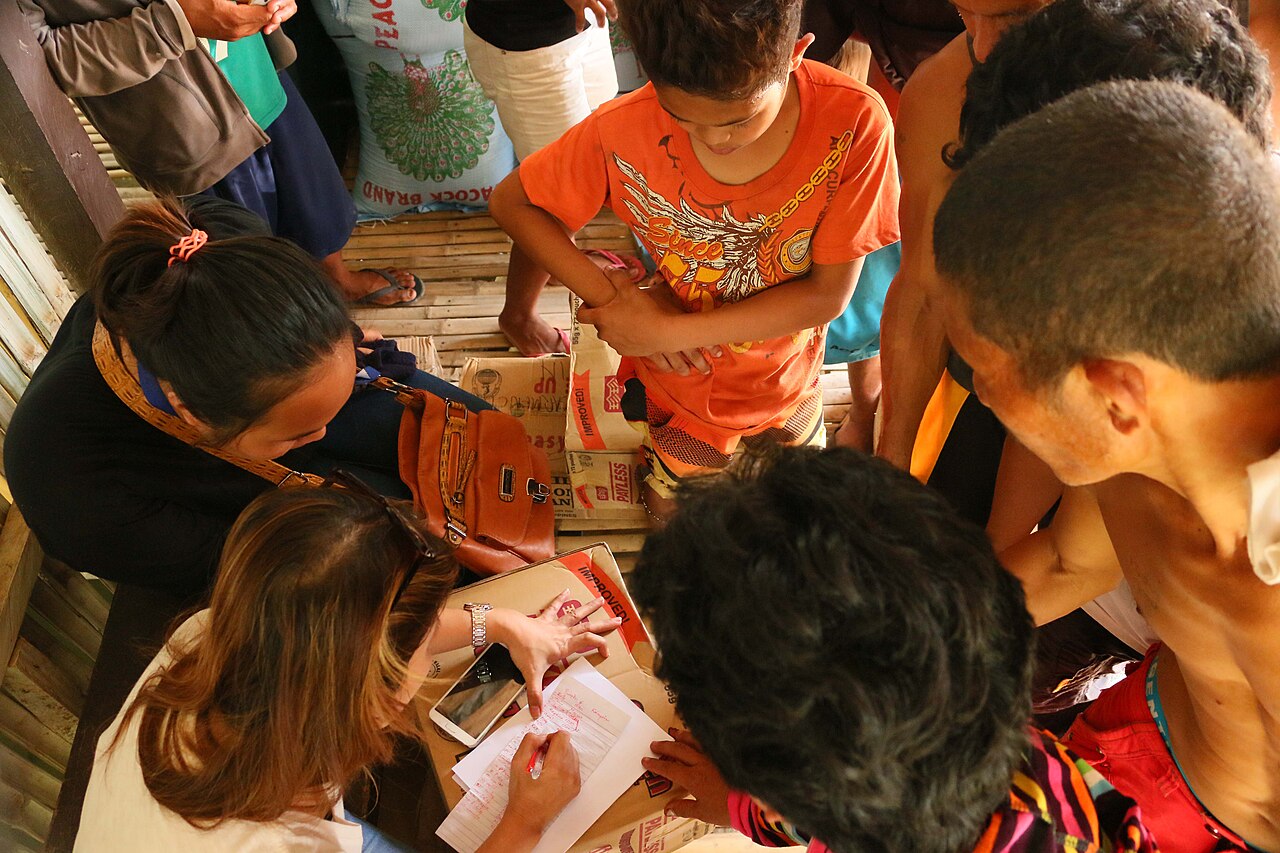 Farmers in (North) Cotabato Province looks at their names from a list as they line up to receive rice donations during the height of El Niño Phenomenon that resulted to the bloody Kidapawan Massacre in March 2016. Braid states that communic